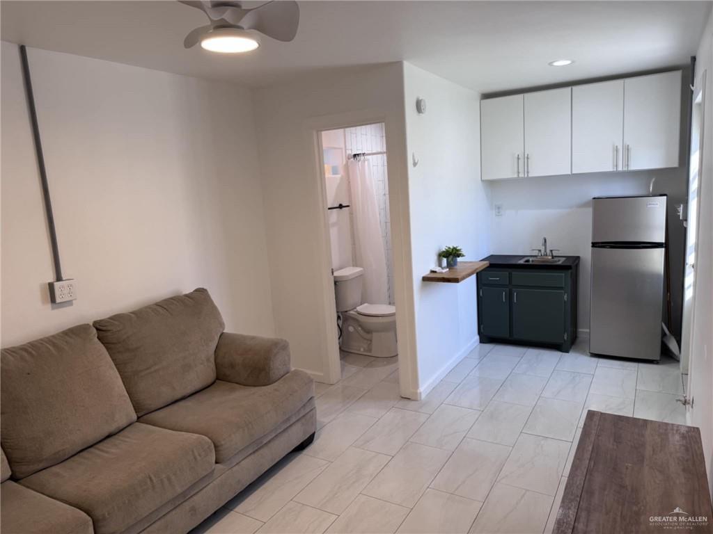 1220 South 8th Avenue Edinburg, TX 78539 - Photo 5 of 10 a living room with furniture and a refrigerator