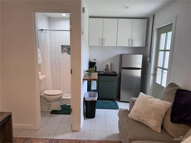 a living room with furniture a refrigerator and a fireplace