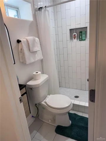 a white toilet sitting next to a bathroom sink and vanity