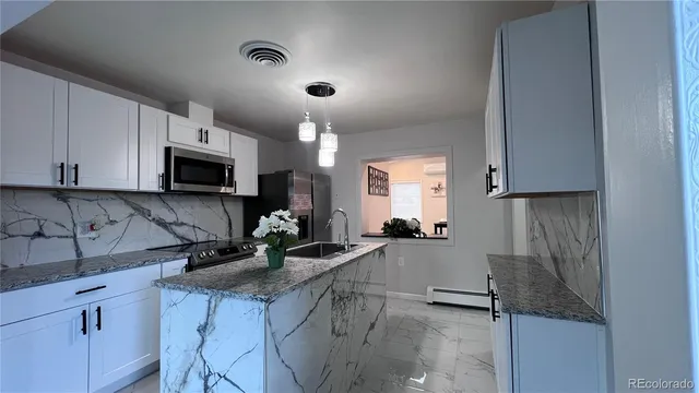 a kitchen with granite countertop a sink a stove and cabinets