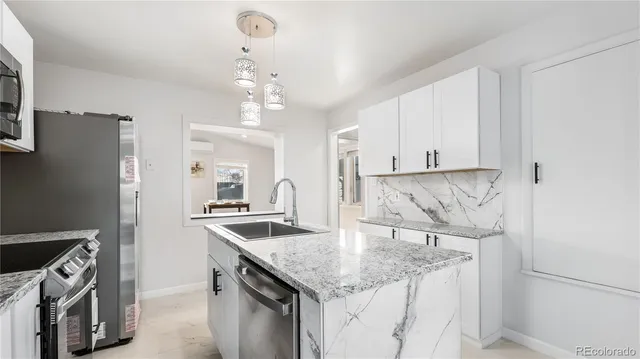 a kitchen with stainless steel appliances granite countertop a sink stove and refrigerator