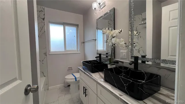 a bathroom with a sink a toilet and a mirror