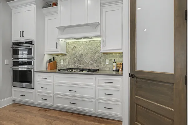 a kitchen with granite countertop white cabinets and stainless steel appliances
