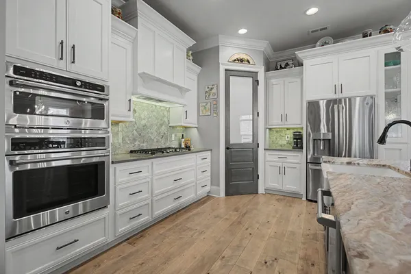 a kitchen with stainless steel appliances a stove a refrigerator and cabinets