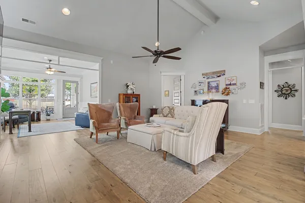 a living room with furniture a ceiling fan a lamp and a window