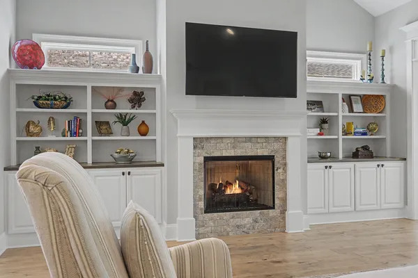 a living room with furniture a flat screen tv and a fireplace