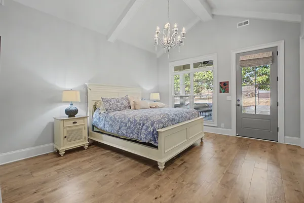 a bedroom with a large bed and a chandelier