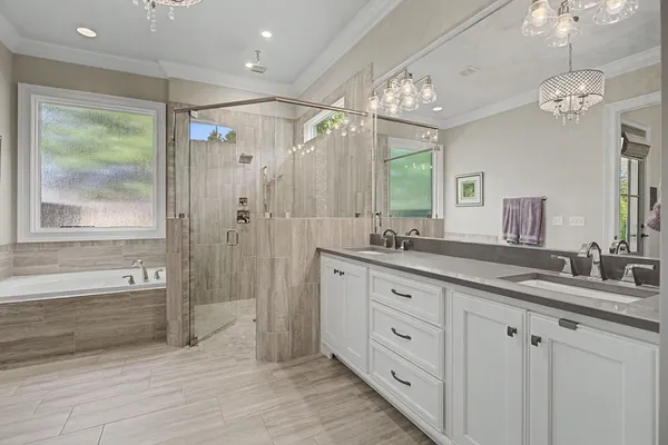 a spacious bathroom with double vanity a shower a a sink and a large mirror