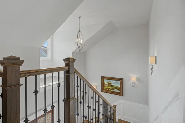 a view of staircase with railing and a chandelier