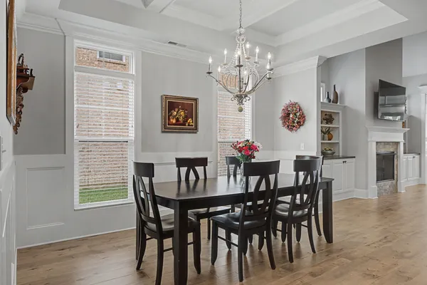 a view of a dining room with furniture a chandelier and wooden floor