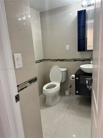 a bathroom with a toilet a sink and a mirror