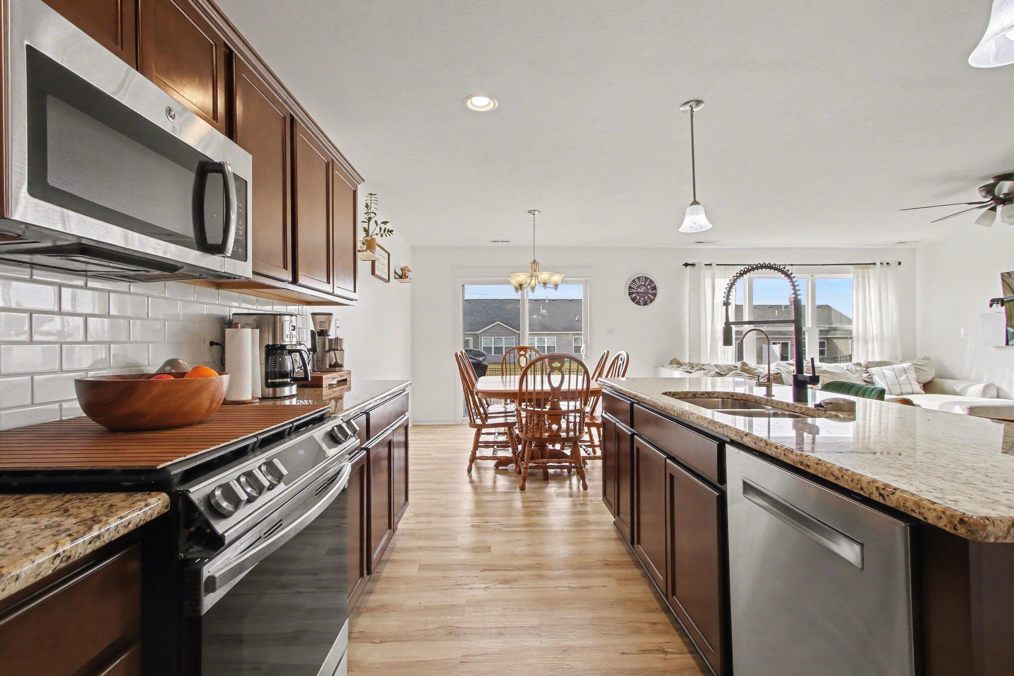 15549 West 101st Place Dyer, IN 46311 - Photo 6 of 14 a kitchen with stainless steel appliances granite countertop a stove a sink and a wooden floors