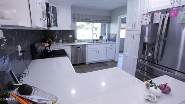 a kitchen with a refrigerator sink and cabinets