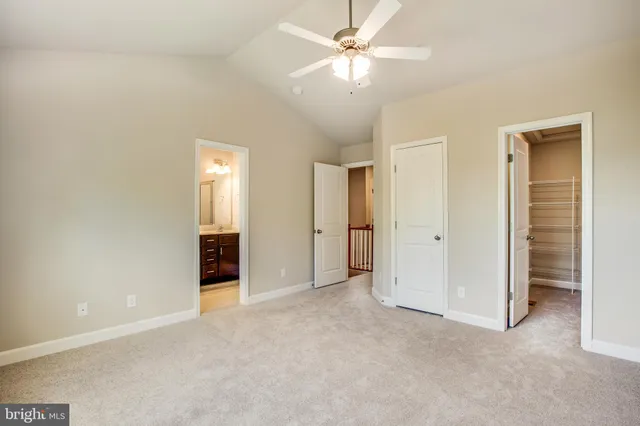 an empty room with closet and a ceiling fan