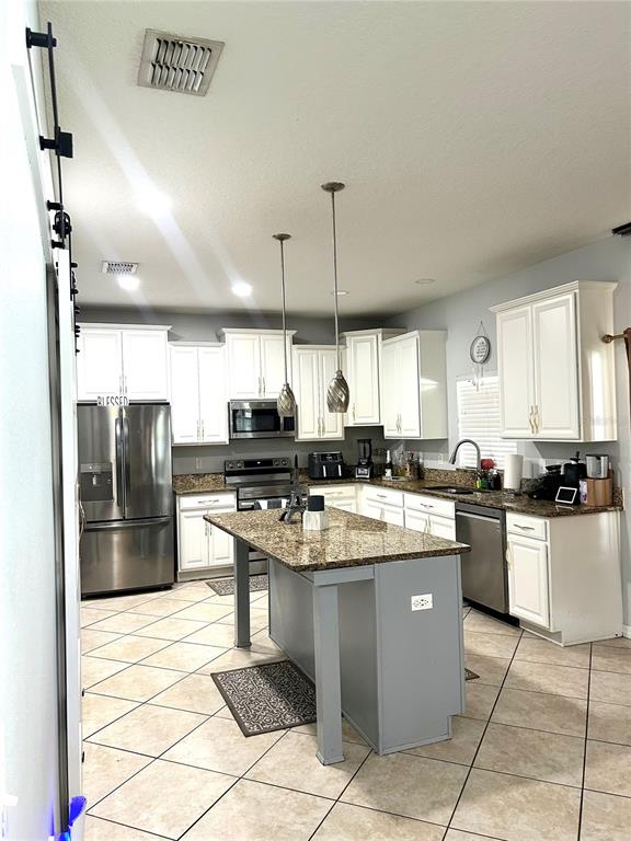 13809 Felix Will Road Riverview, FL 33579 - Photo 20 of 75 a kitchen with stainless steel appliances granite countertop a refrigerator a sink a stove and a wooden floors