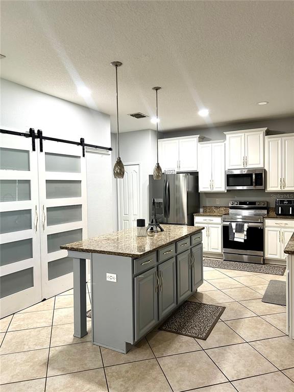 13809 Felix Will Road Riverview, FL 33579 - Photo 22 of 75 a kitchen with stainless steel appliances a stove top oven and a refrigerator