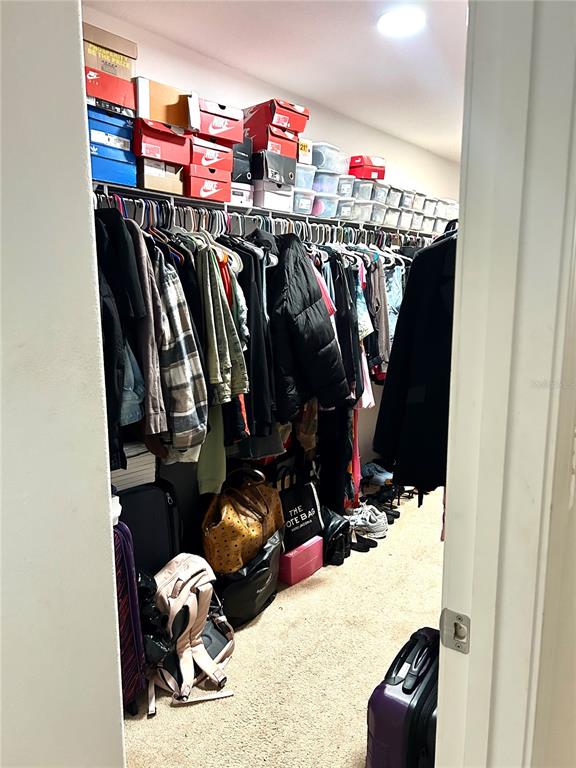 13809 Felix Will Road Riverview, FL 33579 - Photo 45 of 75 a view of walk in closet with clothes and shoes