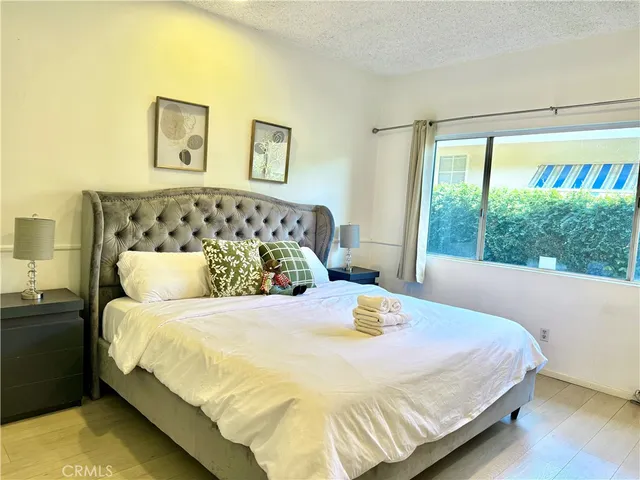 a large bed sitting in a bedroom next to a window