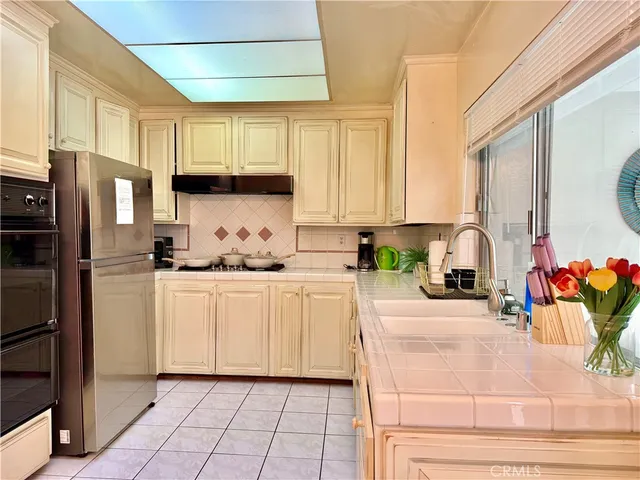 a kitchen with white cabinets and refrigerator