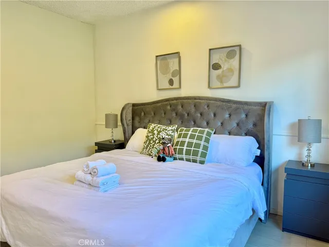 a bedroom with a bed and painting on the wall