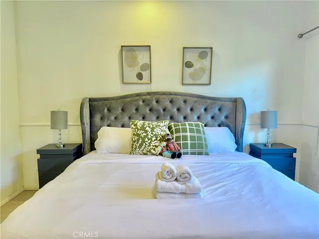 a bedroom with a bed and painting on the wall