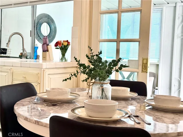 a dining room with furniture and a large window