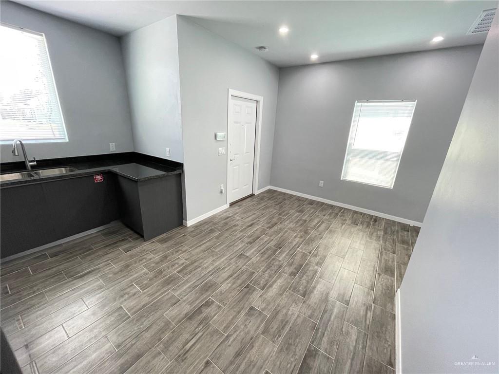 1303 Quitaca Drive, Unit 4 Edinburg, TX 78541 - Photo 6 of 10 an empty room with wooden floor and windows