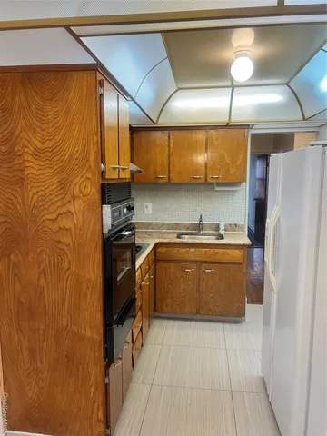 a kitchen with stainless steel appliances granite countertop a refrigerator and a stove
