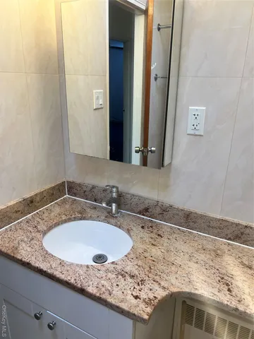 a bathroom with a granite countertop sink and a mirror