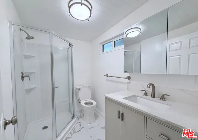 a view of an empty room with closet and mirror