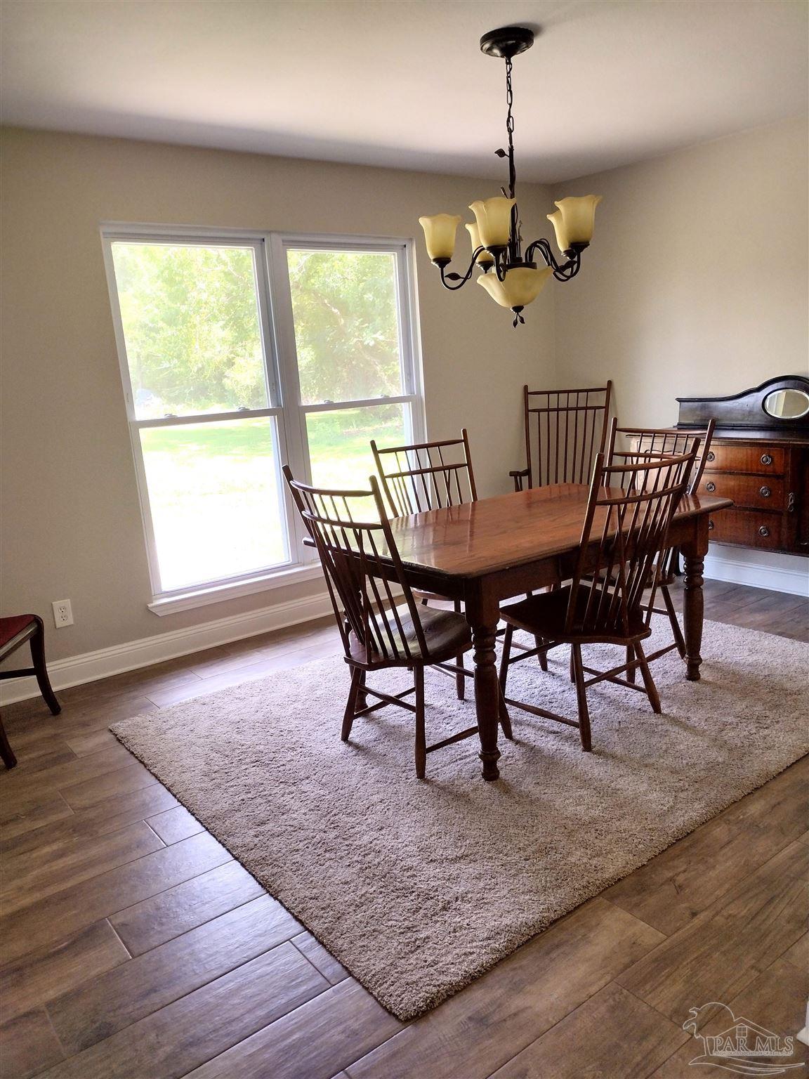4611 Gunter Road Milton, FL 32570 - Photo 6 of 29 a view of a dining room with furniture window and wooden floor