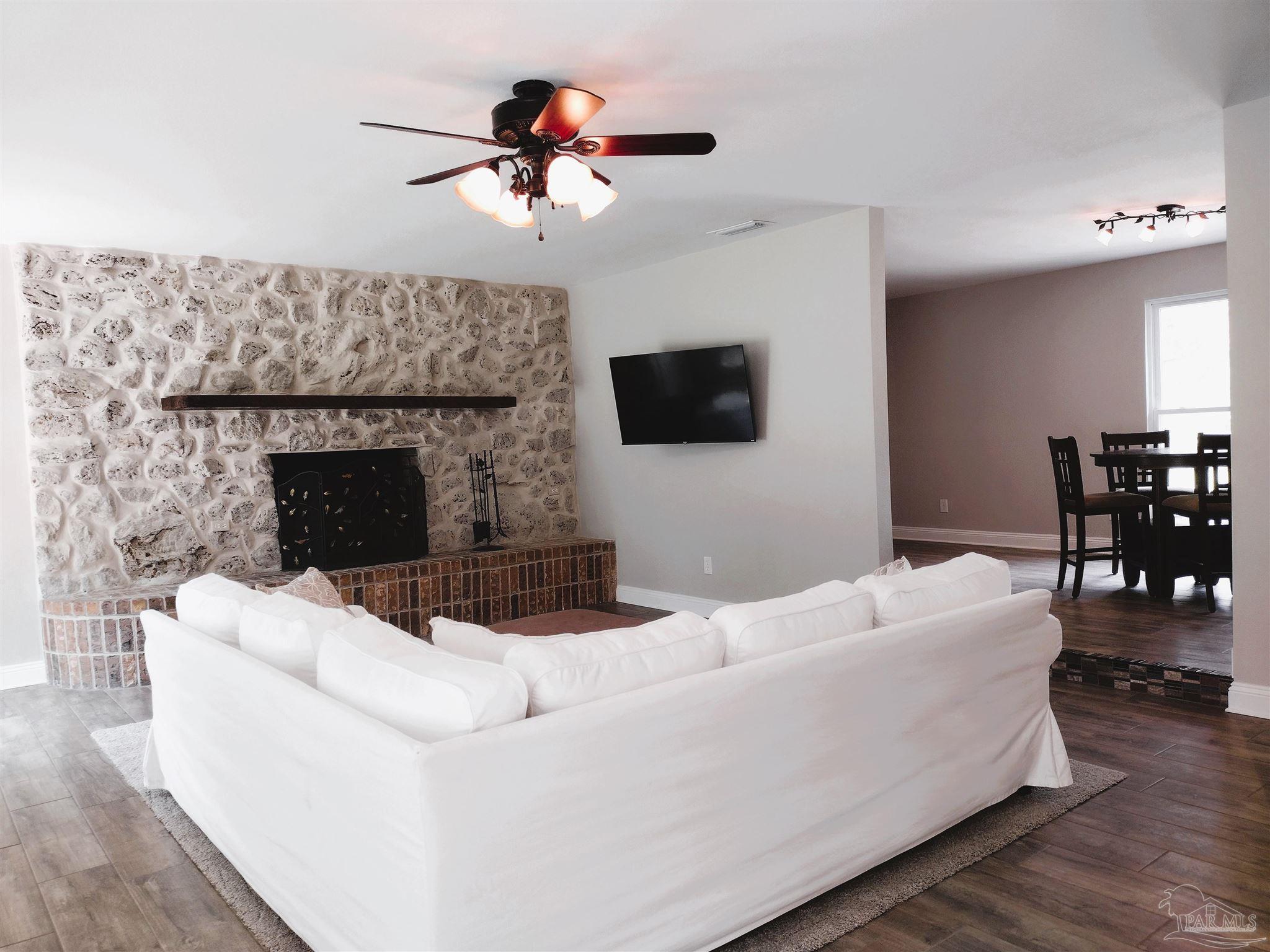 4611 Gunter Road Milton, FL 32570 - Photo 9 of 29 a living room with furniture a fireplace and a flat screen tv