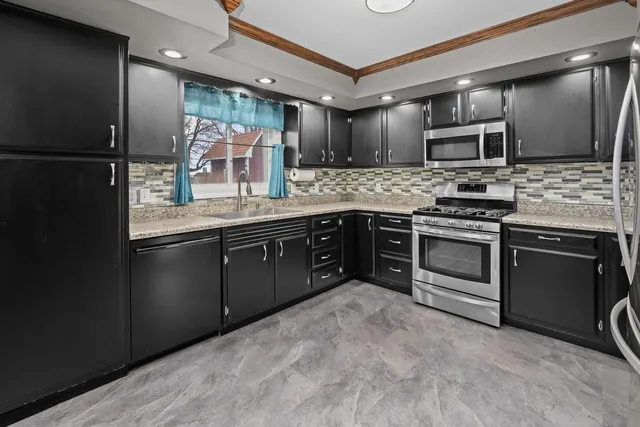 a kitchen with stainless steel appliances granite countertop a stove and a sink