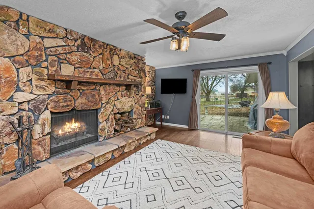 a living room with furniture a fireplace and a floor to ceiling window