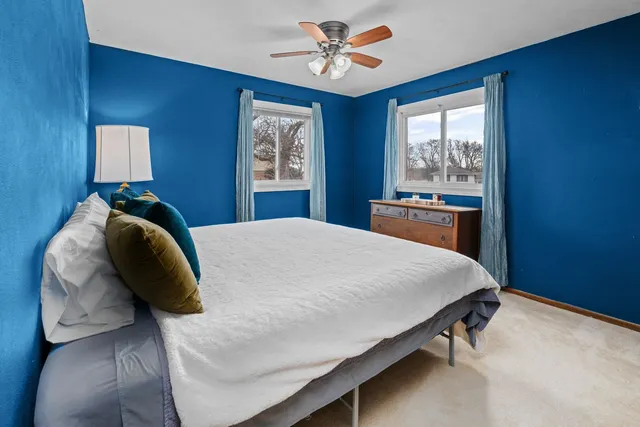 a bed sitting in a bedroom next to a window