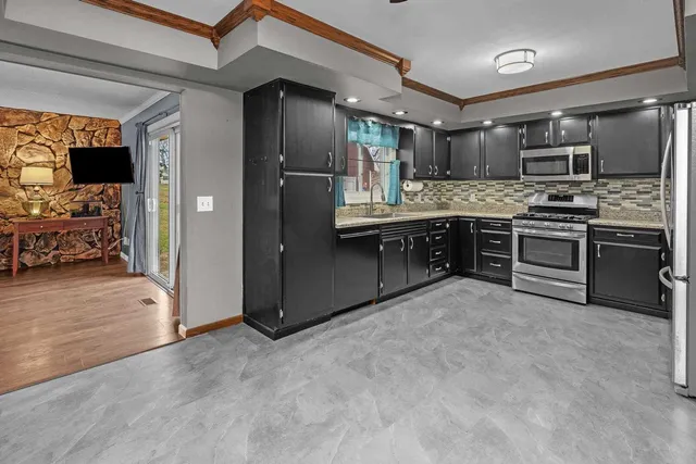 a large kitchen with stainless steel appliances granite countertop a stove and a refrigerator