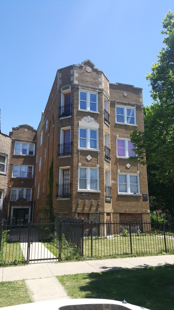 a front view of a residential apartment building with a yard