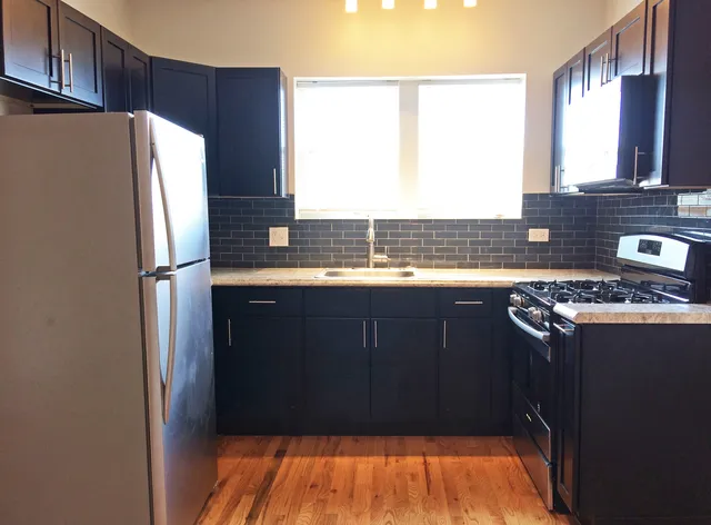 a kitchen with granite countertop a refrigerator and a sink