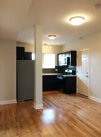 a view of kitchen with refrigerator and stove