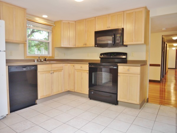 191 Hardy Pond Road Waltham, MA 02451 - Photo 2 of 16 a kitchen with granite countertop a stove top oven microwave and cabinets