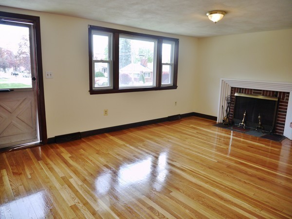 191 Hardy Pond Road Waltham, MA 02451 - Photo 4 of 16 an empty room with wooden floor fireplace and windows