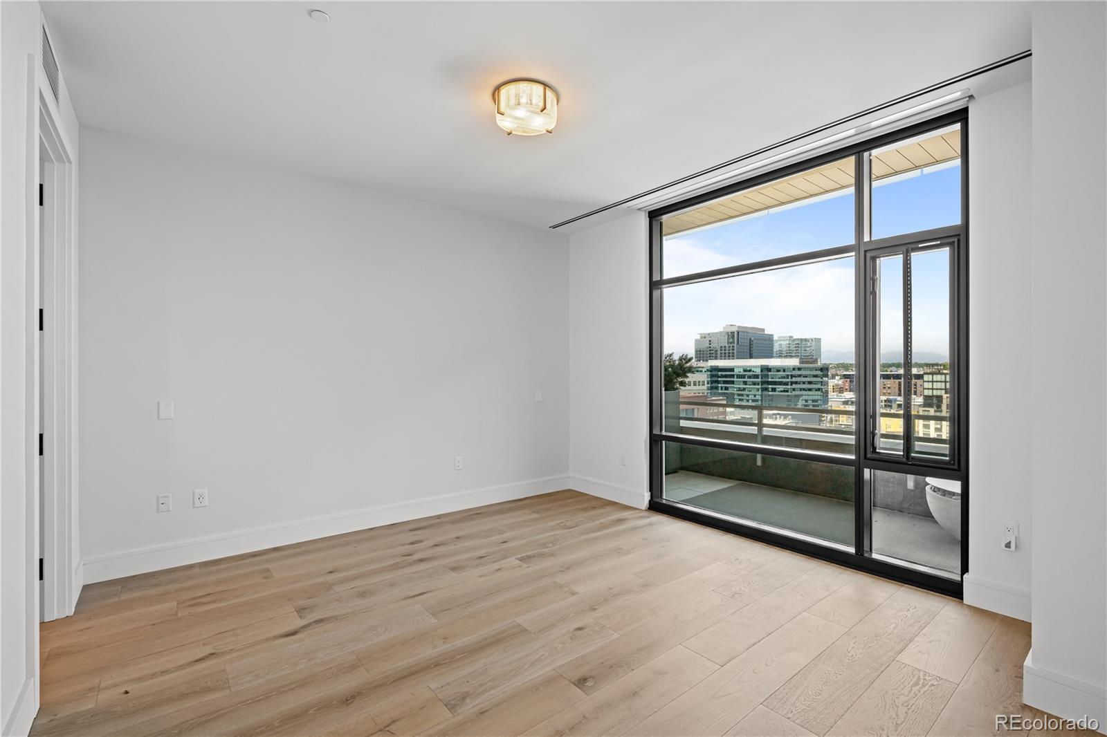 1901 Wazee Street, Unit 1110 Denver, CO 80202 - Photo 13 of 36 an empty room with wooden floor and windows