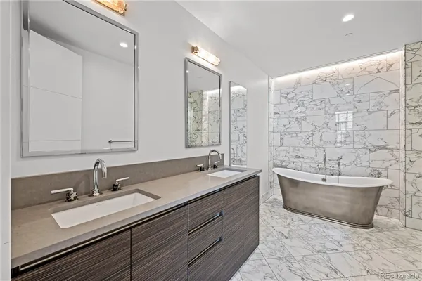 a bathroom with a double vanity sink mirror and bathtub