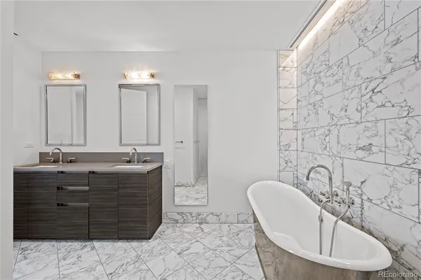 a bathroom with a granite countertop sink and a bathtub