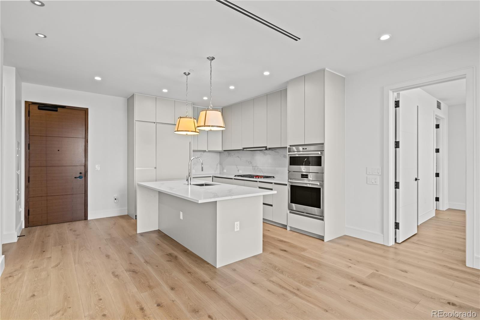1901 Wazee Street, Unit 1110 Denver, CO 80202 - Photo 2 of 36 a large kitchen with stainless steel appliances a large counter top a stove and a refrigerator
