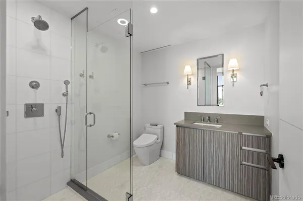 a bathroom with a sink a toilet and shower