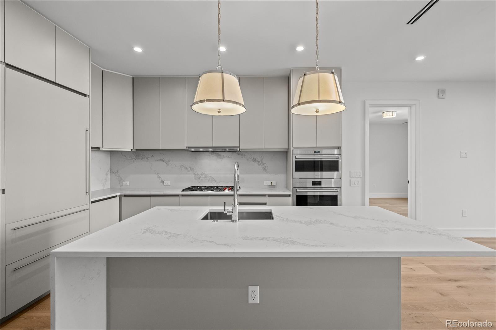1901 Wazee Street, Unit 1110 Denver, CO 80202 - Photo 3 of 36 a kitchen with kitchen island granite countertop a sink a stove and a refrigerator