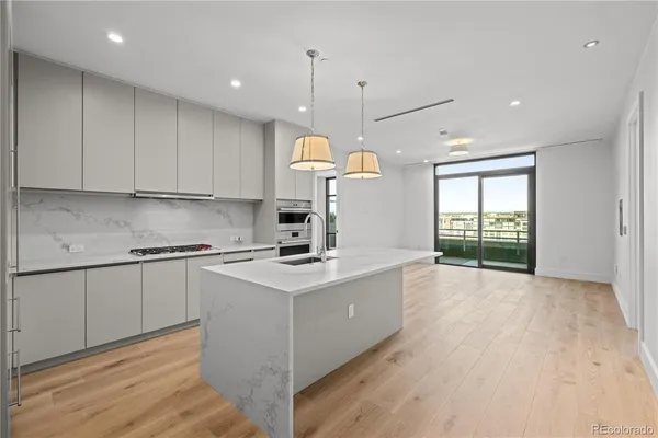 a kitchen with kitchen island white cabinets and wooden floor