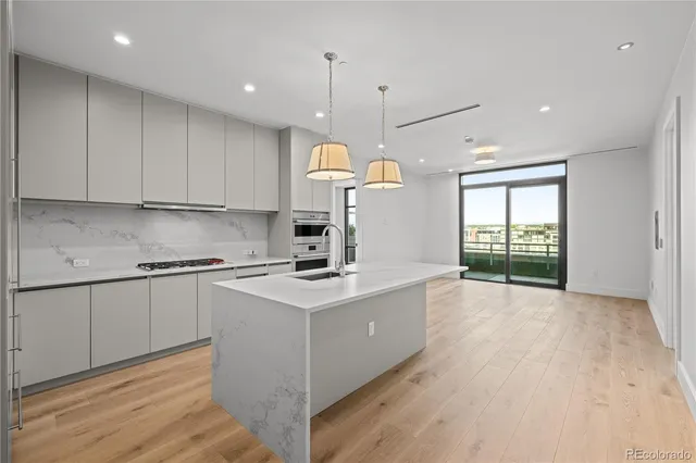 a kitchen with kitchen island white cabinets and wooden floor