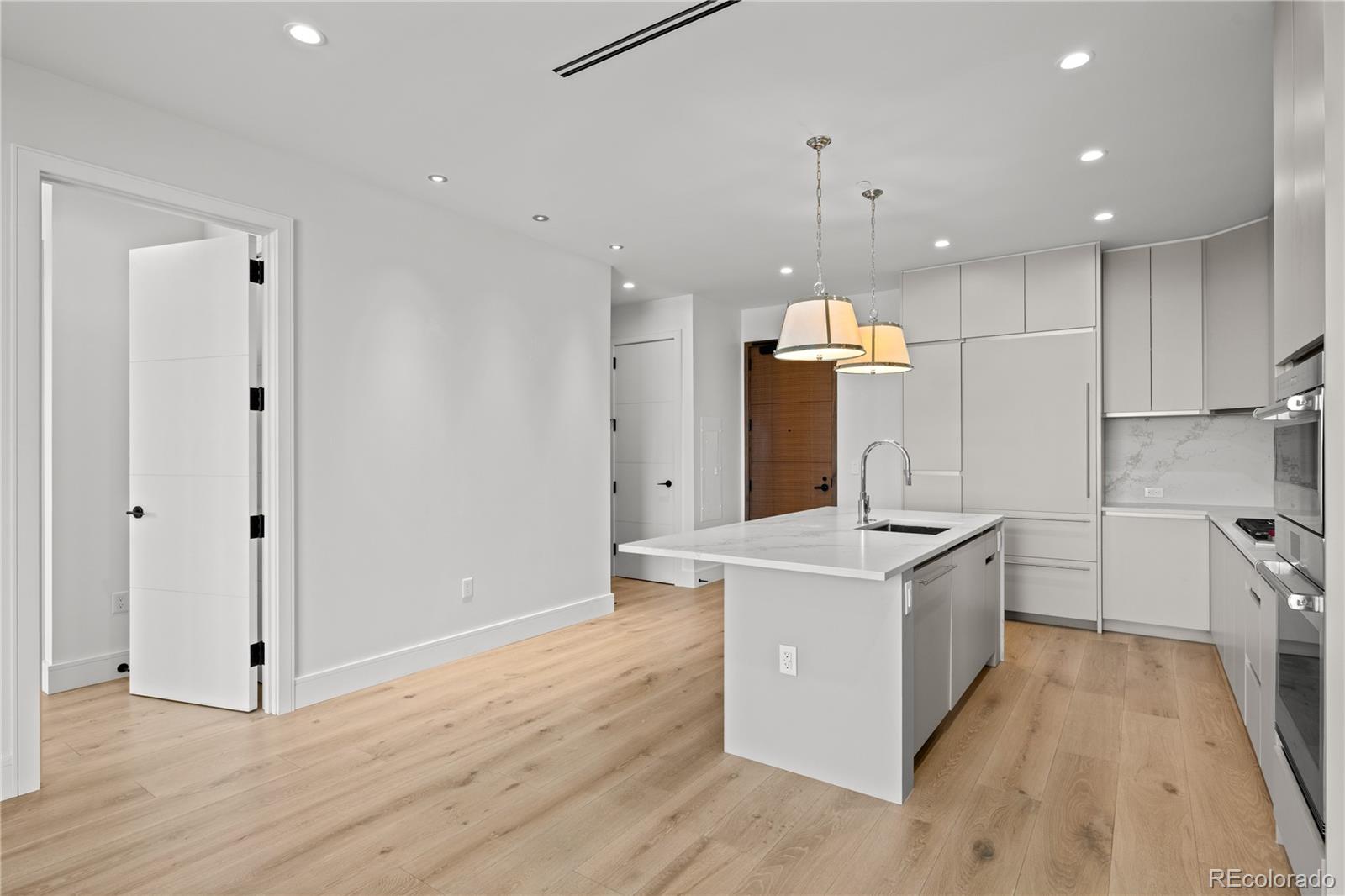 1901 Wazee Street, Unit 1110 Denver, CO 80202 - Photo 8 of 36 a large kitchen with stainless steel appliances granite countertop a sink stove and wooden floors